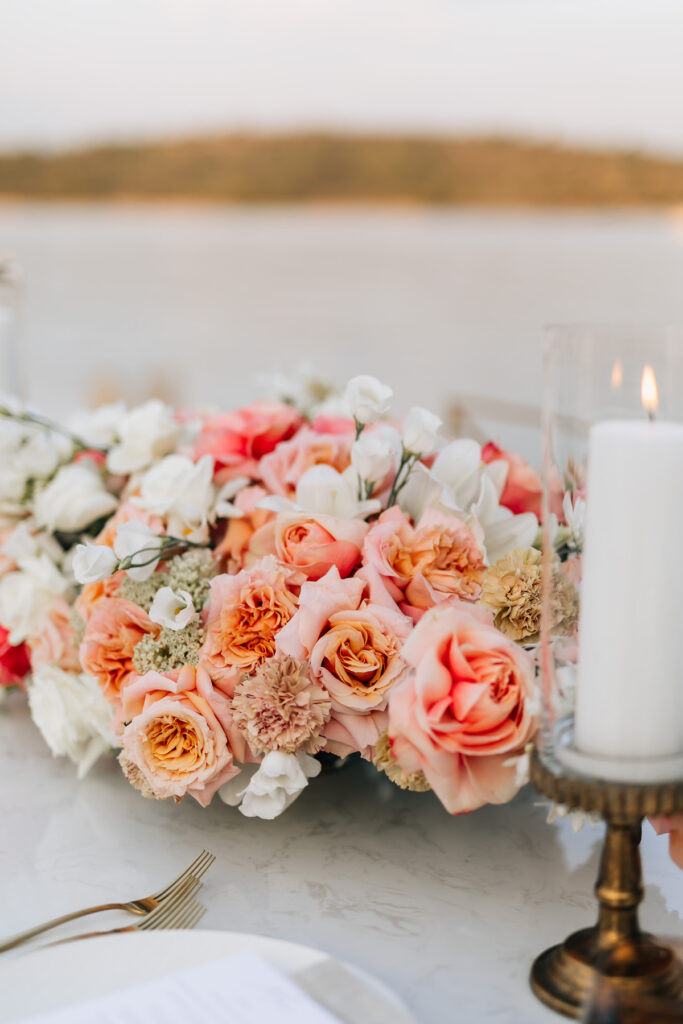 Intimate dinner setup on a private villa’s dock in Croatia, with elegant white linens and guests enjoying a sunset meal beside the Adriatic Sea.
