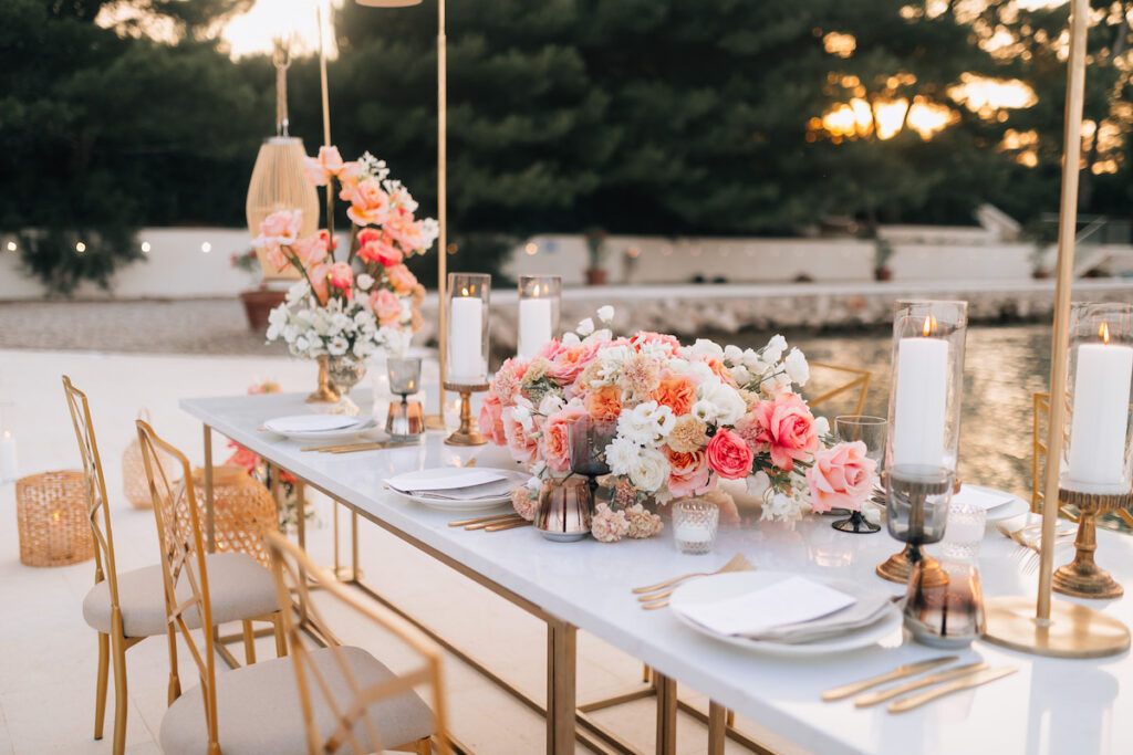 Luxurious dinner table with amber-toned decor, sleek tableware, and a modern design aesthetic, surrounded by sea views and warm evening light.