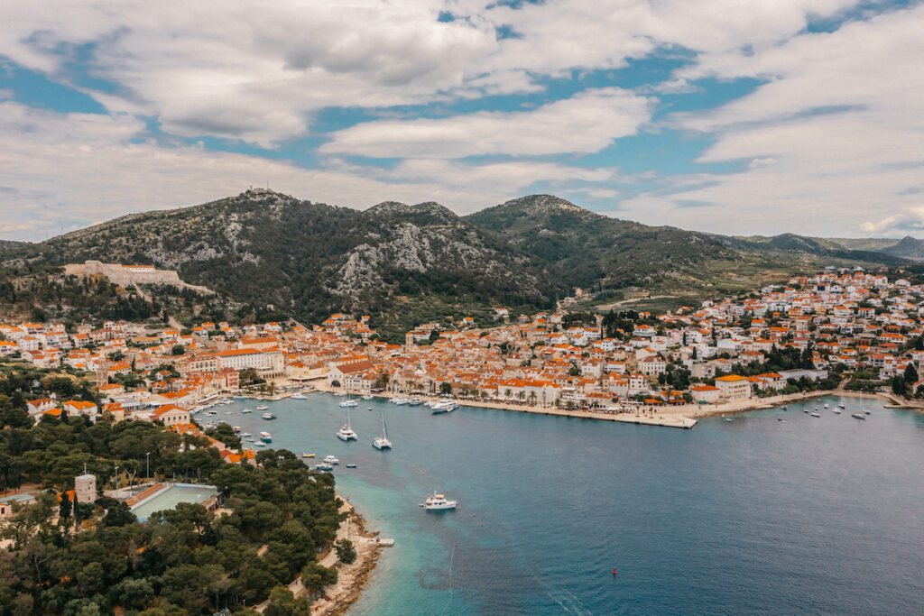 Emotional wedding ceremony at Park Hvar with panoramic sea views, the bride wiping away tears as the groom reads his vows under a floral boho arch.