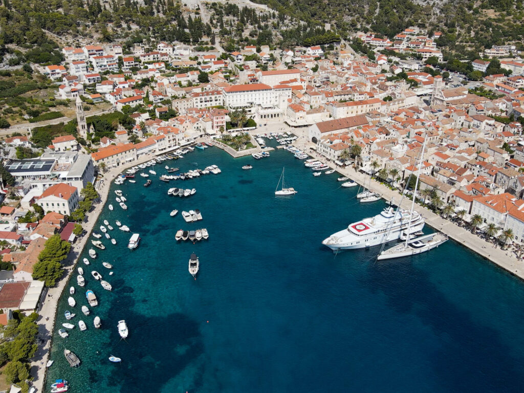 A panoramic aerial view of Fortress Hvar overlooking the Adriatic Sea, with historic stone walls and the vibrant town of Hvar below.