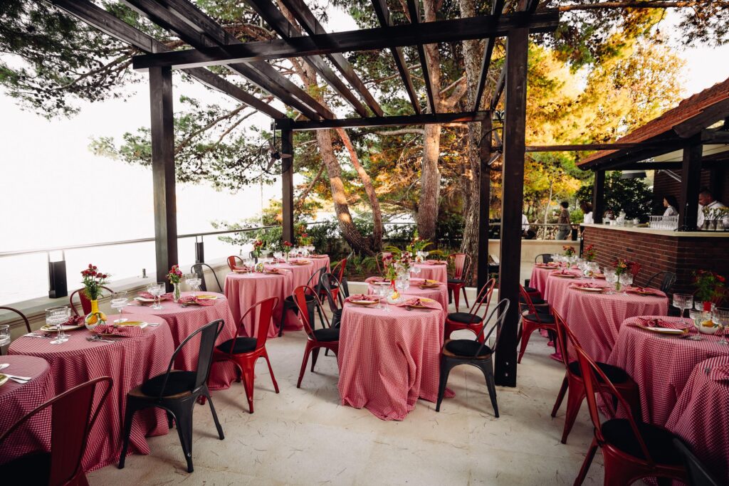 Retro event setup featuring red checkered tablecloths, dim lighting, and vintage decor.