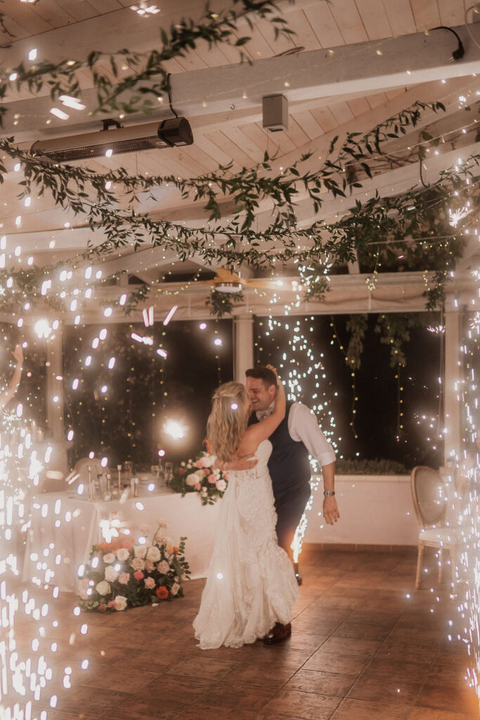 Elegant floral arrangements in shades of pink, blush, and orange adorning a wedding ceremony setup, creating a romantic and vibrant atmosphere.