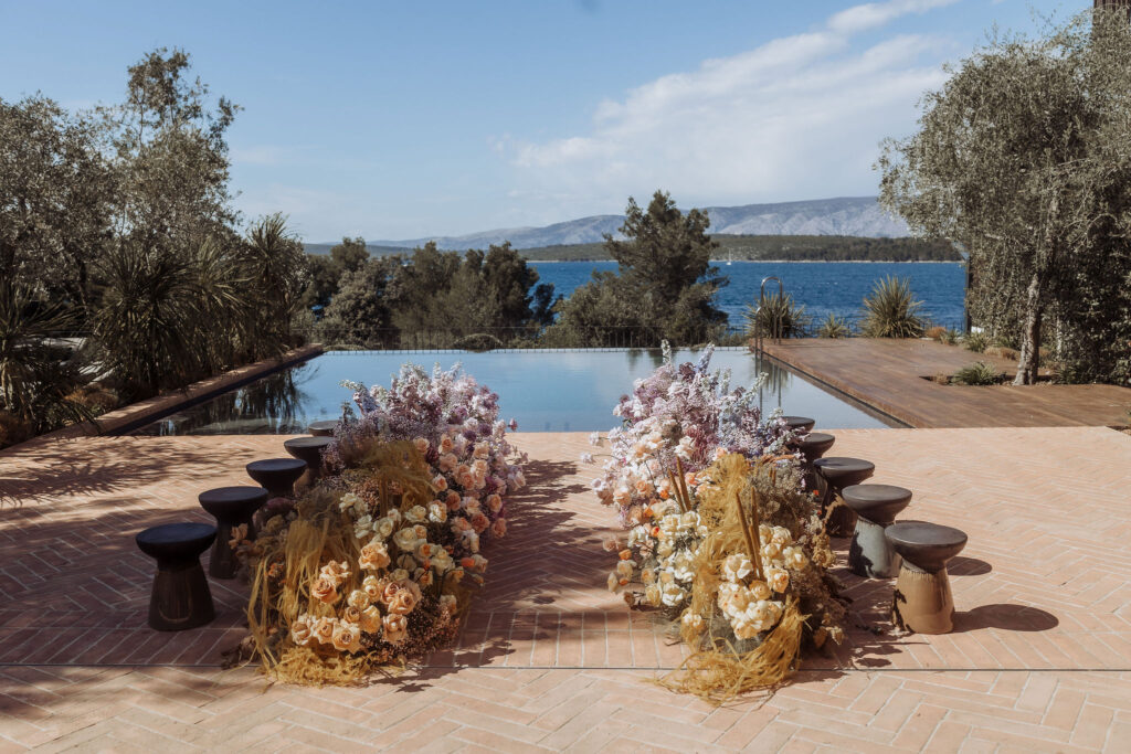 Elegant wedding ceremony setup at Maslina Resort, featuring pastel-colored floral arrangements and the crystal-clear Adriatic waters in the background