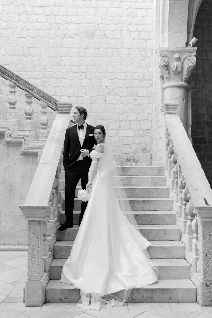 Morgan and Robbie’s three-day Dubrovnik wedding with a Hilton welcome dinner, Banje Beach party, and St. Lawrence Fortress ceremony, featuring signature cocktails, vintage bells, drummers, and a lively French band.