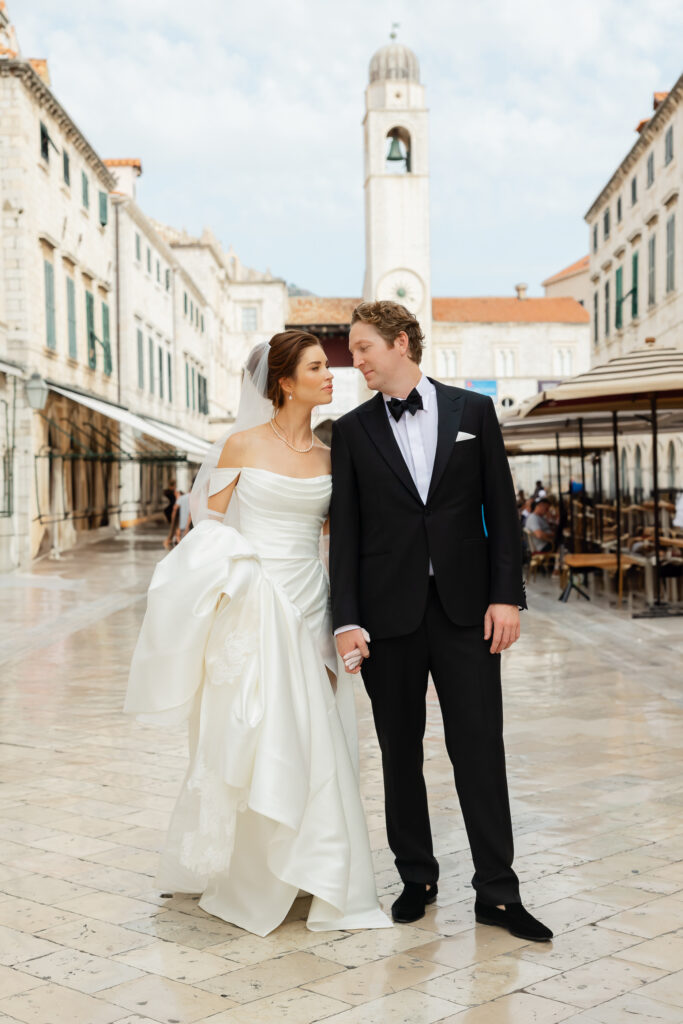 Morgan and Robbie’s three-day Dubrovnik wedding with a Hilton welcome dinner, Banje Beach party, and St. Lawrence Fortress ceremony, featuring signature cocktails, vintage bells, drummers, and a lively French band.