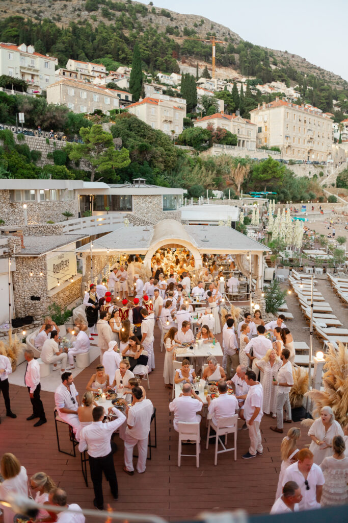 Morgan and Robbie’s three-day Dubrovnik wedding with a Hilton welcome dinner, Banje Beach party, and St. Lawrence Fortress ceremony, featuring signature cocktails, vintage bells, drummers, and a lively French band.